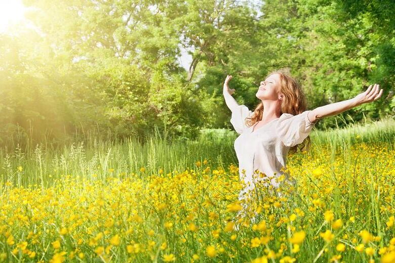 blissful woman with arms stretched out to the side